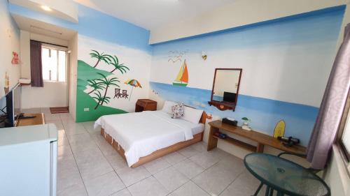 a bedroom with a bed and a desk and a mirror at Lang Jiao Ya She Homestay in Hengchun