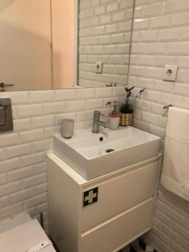 Un baño blanco con lavabo y espejo. en Central charming apartment, en Oporto