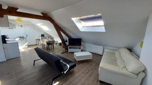 a living room with a white couch and a table at Studio tout confort 2 personnes en plein centre ville in Roye
