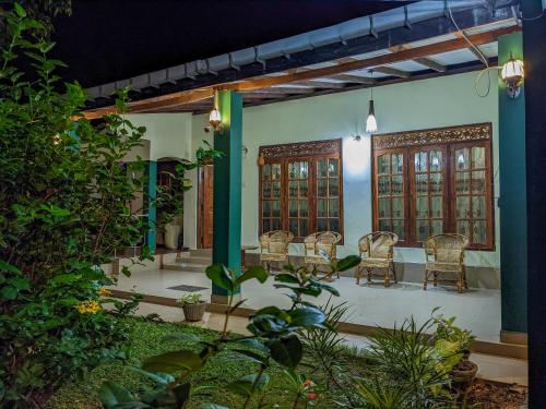 a patio in a house with chairs and plants at Choona Lodge 'view of sigiriya & pidurangala with sunrise' in Sigiriya