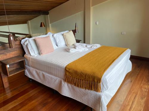 a bedroom with a large bed with white sheets and pillows at Loft Maika'i in Santo Antônio do Pinhal