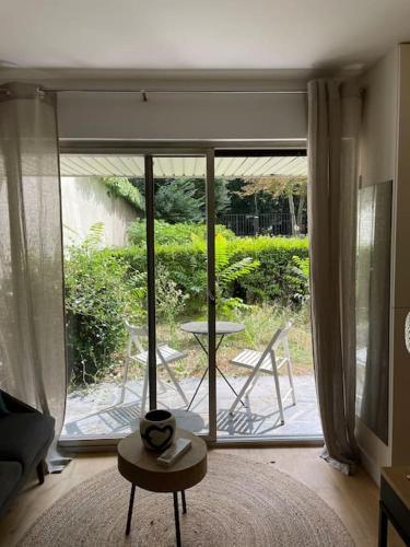 d'un salon avec une grande porte coulissante en verre. dans l'établissement Agréable et moderne studio à Neuilly avec jardin, à Neuilly-sur-Seine