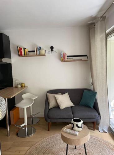 a living room with a couch and a table at Agréable et moderne studio à Neuilly avec jardin in Neuilly-sur-Seine