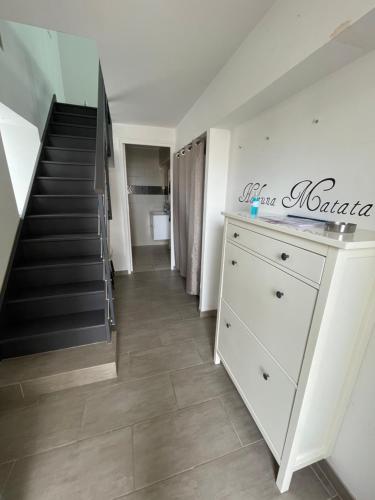 a room with a staircase and a dresser in front of a stairs at Loft Chez Guillaume in Bouleurs