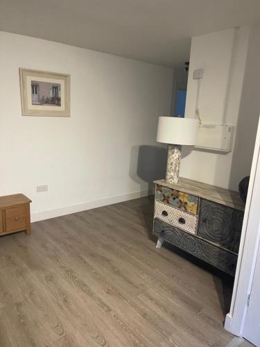 a room with a lamp on a dresser and a mirror at Apple Barn Guest House in Wisbech