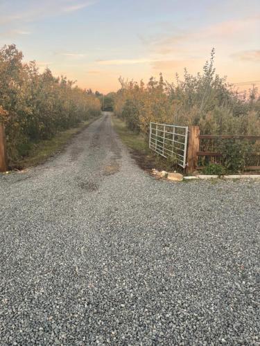 a gravel road with a gate on the side at Apple Barn Guest House in Wisbech