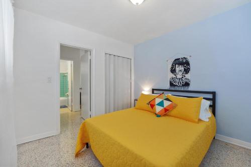 a bedroom with a yellow bed with a skull picture on the wall at Miami 1 Bedroom Apt With Parking in Miami