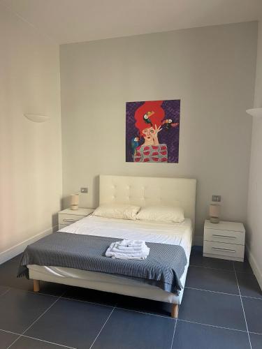 1 dormitorio con 1 cama y una pintura en la pared en THE LITTLE KATIA'S HOME, en Caserta