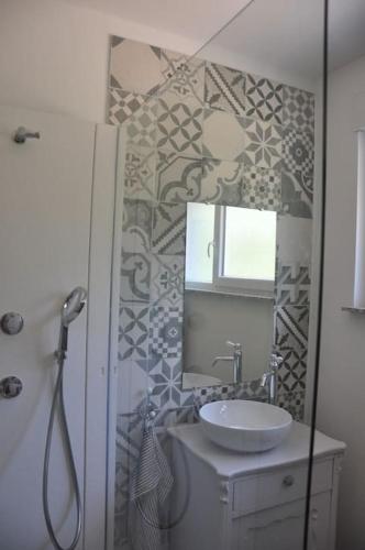 une salle de bain avec un lavabo et un miroir dans l'établissement Gite St Nicolas ancien corps de ferme horticole, à Freyming-Merlebach