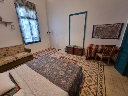 a bedroom with a bed and a couch and a chair at Shams House in Amman