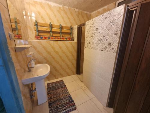 a small bathroom with a sink and a shower at Shams House in Amman