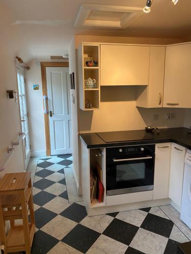 una cocina con suelo a cuadros en blanco y negro en Cosy Cottage in beautiful Royal Deeside, en Aboyne