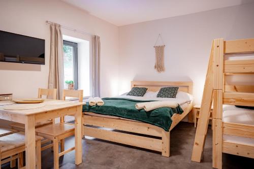 a bedroom with a bed and a desk and a table at Apartmány NONE in Branná