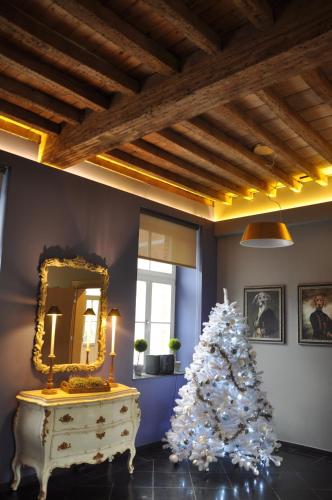 a christmas tree in a room with a mirror at Aparthotel Le Manoir du Capitaine in Feluy