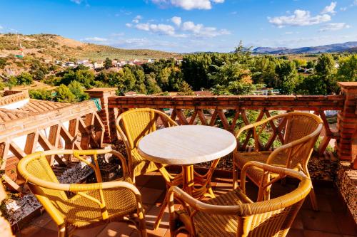 a table and chairs on a balcony with a view at La Atalaya in Frailes