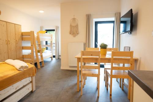 a room with a table and chairs and a bedroom at Apartmány NONE in Branná