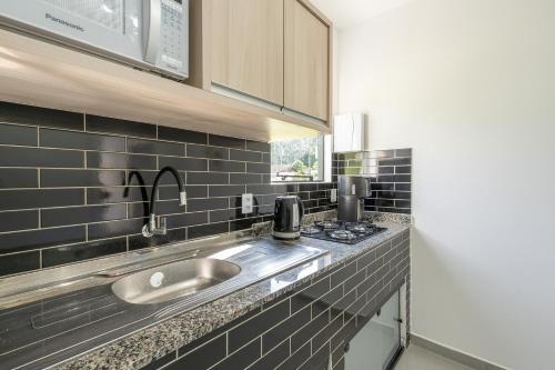 um balcão de cozinha com um lavatório e um fogão em Casa c Wi-Fi e otima localizacao - Testo Salto SC em Blumenau