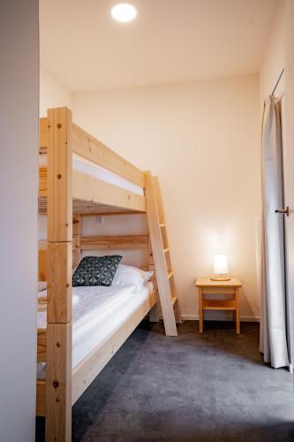 a bedroom with two bunk beds and a table at Apartmány NONE in Branná