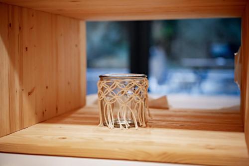 a glass cup sitting on top of a wooden shelf at Apartmány NONE in Branná