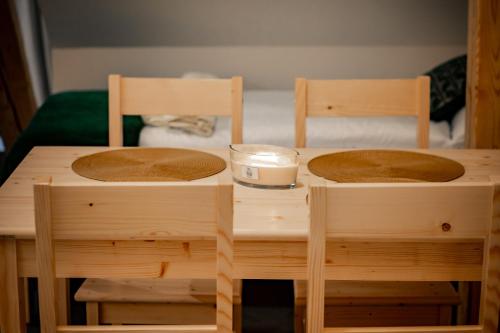 a wooden table with two chairs and a candle on it at Apartmány NONE in Branná