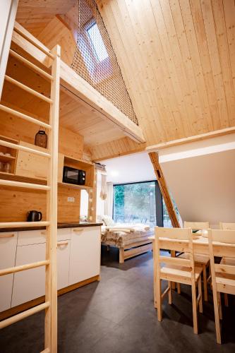 a room with a bunk bed and a table and chairs at Apartmány NONE in Branná