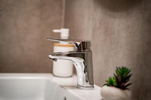 a bathroom sink with a faucet on a sink at Apartmány NONE in Branná
