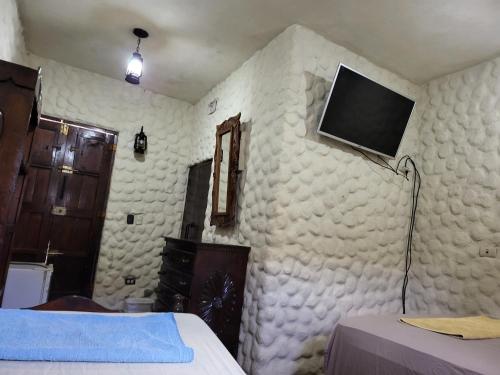 a bedroom with a wall with a tv on it at Hostal casa de las gargolas in Amapala