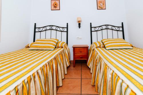 Frailes的住宿－La Martina，客房内的两张床和条纹床单