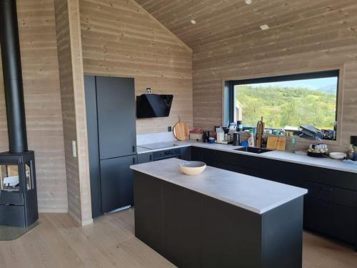 eine Küche mit einer Theke und einem großen Fenster in der Unterkunft Fjellhytte på hardangervidden med uforglemmelig utsikt! in Garden