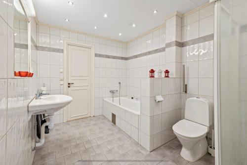 La salle de bains blanche est pourvue de toilettes et d'un lavabo. dans l'établissement Beautiful Home in the Swedish landscape, à Vissefjärda