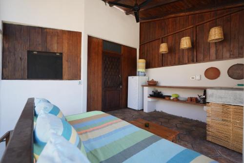 a living room with a bed and a kitchen at Casa Nudista - LGBT Hotel in Zipolite