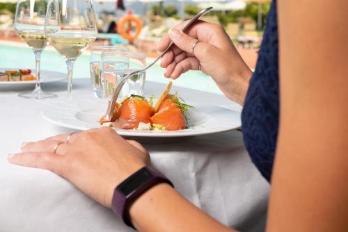 a person sitting at a table with a plate of food at Hotel Airone isola d'Elba in Portoferraio