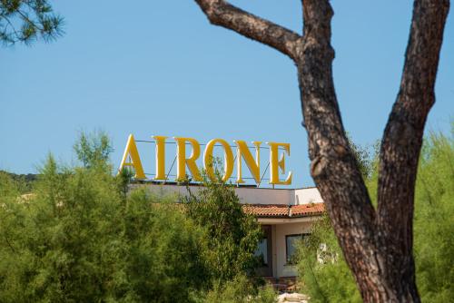 a sign on top of a arena building with trees at Hotel Airone isola d'Elba in Portoferraio