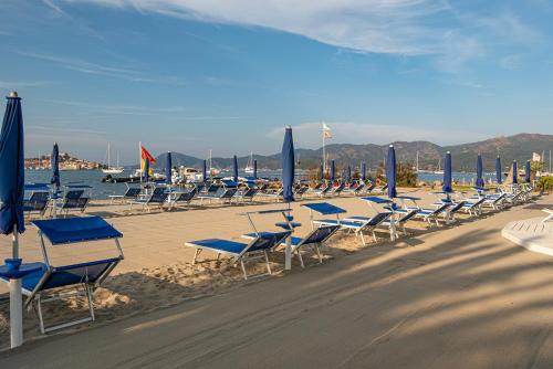 a bunch of chairs and umbrellas on a beach at Hotel Airone isola d'Elba in Portoferraio
