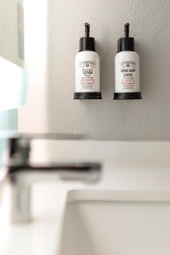 two bottles ofodorizers sitting on a wall above a sink at Holiday Inn & Suites - Mt Juliet Nashville Area by IHG in Mount Juliet