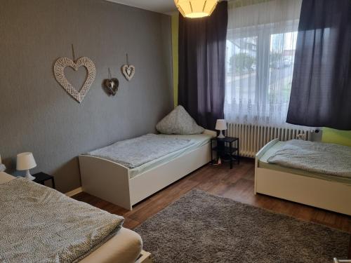 a bedroom with two beds and a heart on the wall at Ferienwohnung Toge in Wadgassen