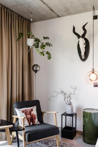 a living room with a chair and a clock on the wall at Sommers "Schöne Aussicht", Adults only in Reichenbach im Vogtland