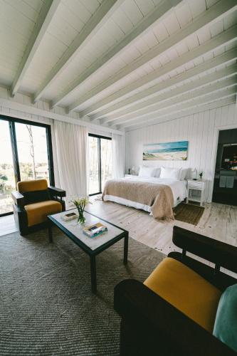 a bedroom with a bed and a couch and a table at Casa Flor in Punta del Este
