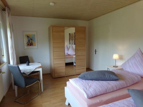 a bedroom with a bed and a desk and a mirror at Ederauenblick in Dodenau