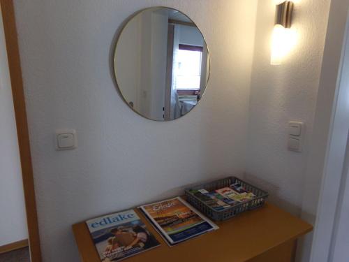 a bathroom with a mirror and a table with magazines at Ederauenblick in Dodenau