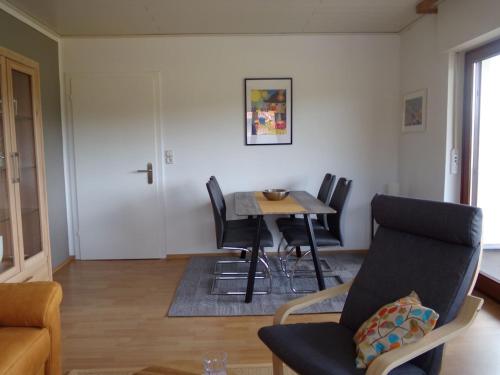 a living room with a dining room table and chairs at Ederauenblick in Dodenau