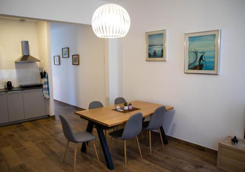 uma cozinha e sala de jantar com uma mesa de madeira e cadeiras em Beocio Home • The hidden gem in Murano’s heart em Murano