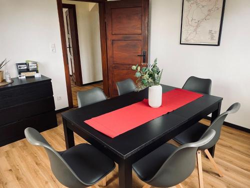 a black dining room table with chairs and a red napkin at Ringtoys Rooms in Welcherath