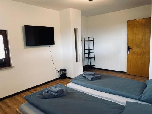 a room with two beds and a television on the wall at Ringtoys Rooms in Welcherath