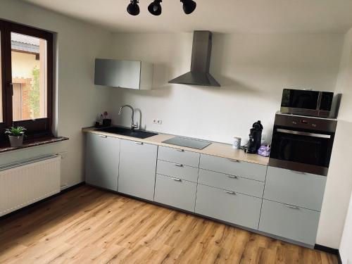 a kitchen with white cabinets and a stove top oven at Ringtoys Rooms in Welcherath