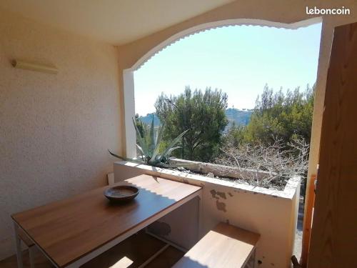 une pièce avec une table et une grande fenêtre dans l'établissement Appartement de charme Saint Mandrier sur Mer, à Saint-Mandrier-sur-Mer