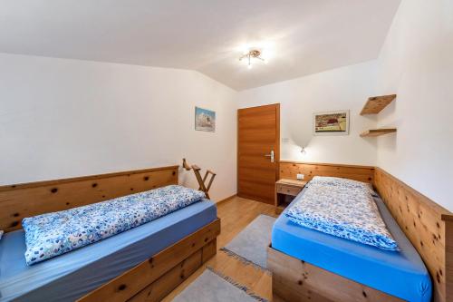 a bedroom with two beds and a closet at Florerhof Ferienwohnung Flieder in Vols am Schlern