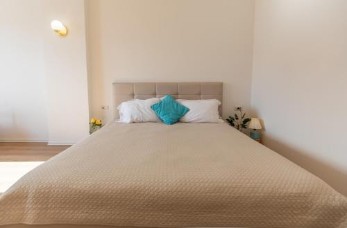 1 dormitorio con 1 cama grande y 2 almohadas azules en New Apartament, en Tirana