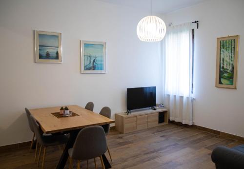 uma sala de estar com uma mesa e uma televisão em Beocio Home • The hidden gem in Murano’s heart em Murano