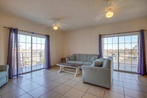 a living room with couches and a table and windows at Americana Condos 10th street in Ocean City